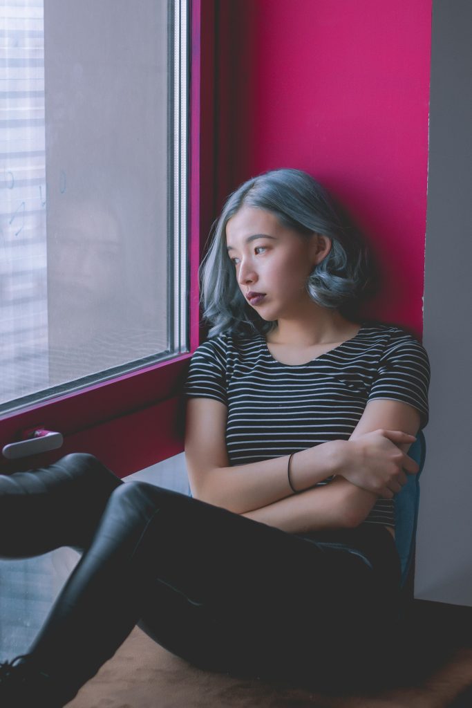 Grieving woman looking out window